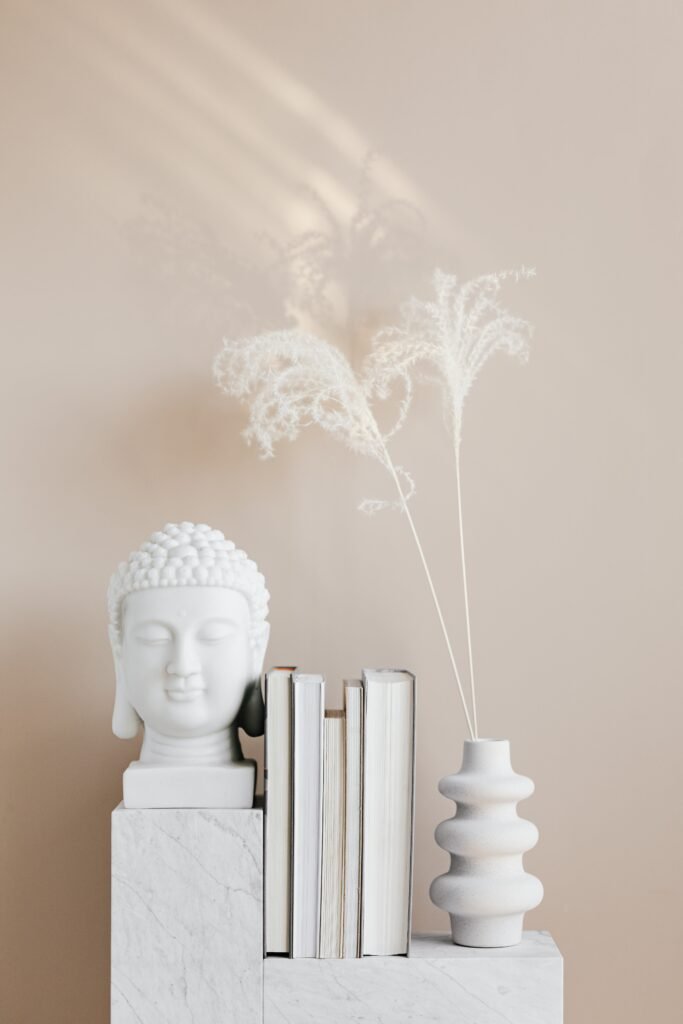 Vase with dried herbs arranged with Buddha bust and books